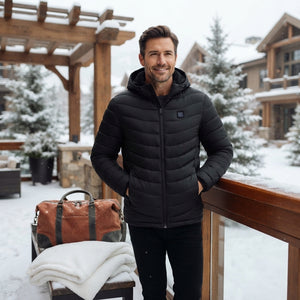A man wearing a heated winter parka standing in a snowy environment, looking warm and comfortable.